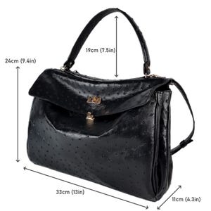 May include: Black handbag with a textured surface, a top handle, and a flap closure. The bag measures 13 inches wide, 9.4 inches high, and 4.3 inches deep, with a handle height of 7.5 inches.