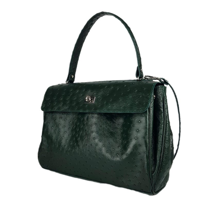 May include: A dark green leather handbag with a top handle and a flap closure. The bag has a textured surface and a silver-colored clasp. The handle is curved and attached to the top of the bag. The bag is approximately 12 inches wide.