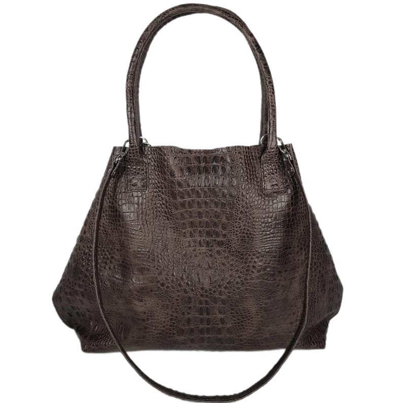May include: A brown leather tote bag with a crocodile embossed pattern. The bag has two top handles and a long shoulder strap.
