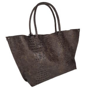 May include: A large brown tote bag with a crocodile-embossed leather design. The bag has two top handles and a spacious interior.
