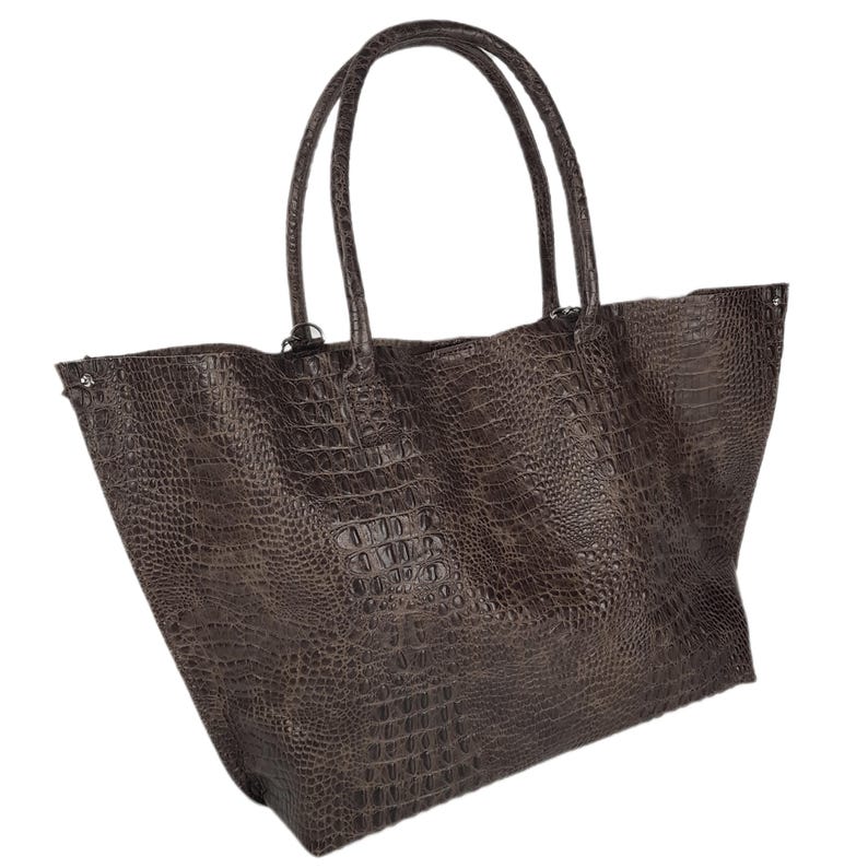 May include: A large brown tote bag with a crocodile-embossed leather design. The bag has two top handles and a spacious interior.