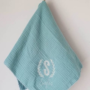 Embroidered and personalized baby swaddle with an initial wreath of leaves and a first name. Several colors to choose from. image 1