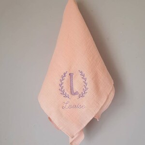 Embroidered and personalized baby swaddle with an initial wreath of leaves and a first name. Several colors to choose from. Rose Blush