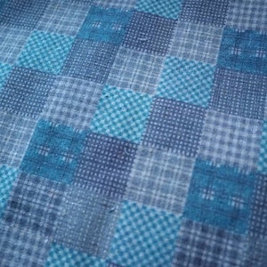 Op de afbeelding: Een blauwe en witte geruite stof met een subtiel textuurpatroon. De stof heeft een geweven uiterlijk en is gemaakt van een zacht, comfortabel materiaal.