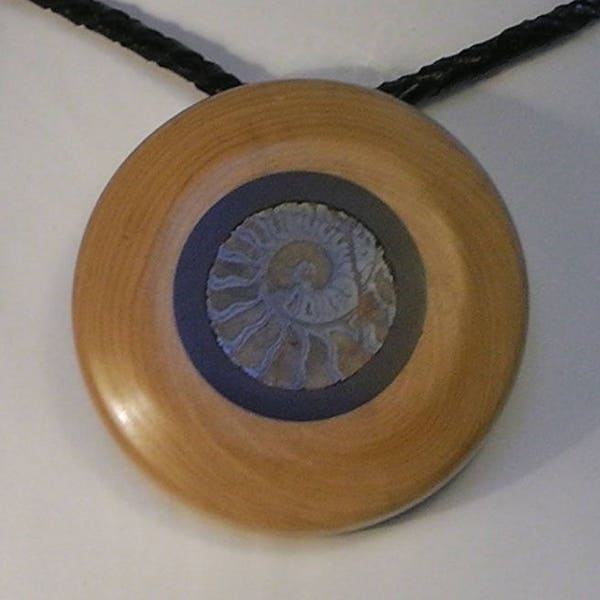 Collier tourné en bois de  buis et cerclage d' ébène et incrustation d'une d'Ammonite, sur cordon de cuir tressé, "Duo"