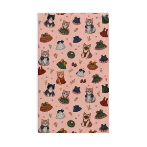 Peut inclure: Un tissu rectangulaire rose avec un motif répété de chats de dessins animés portant des robes et des tenues. Les chats sont dans différentes poses, avec des robes vertes, bleues et rouges. De petites fleurs et d'autres éléments décoratifs parsèment le motif.