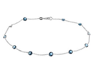 May include: A silver chain necklace with blue gemstones. The necklace has a delicate chain and round blue stones.