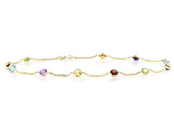 May include: A gold chain necklace with colorful gemstones. The necklace features a variety of round, faceted gemstones in shades of blue, green, purple, and orange.