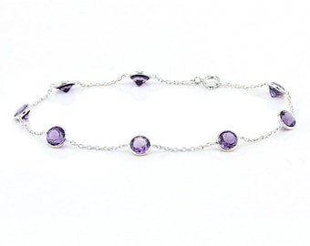 Può includere: Un delicato bracciale in argento con pietre preziose rotonde di colore viola. Il bracciale è composto da una sottile catena con pietre distanziate uniformemente e una chiusura sicura. Le pietre sono incastonate in un design semplice ed elegante.