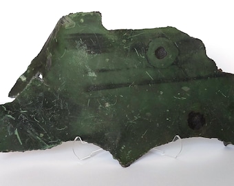 May include: A large, green, irregularly shaped piece of metal with two circular holes. The metal has a rough, textured surface and appears to be weathered.