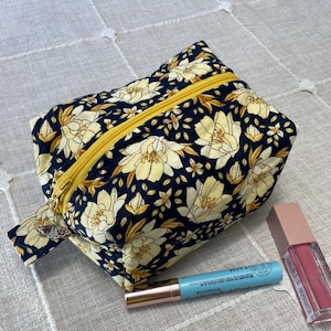 Gesteppte Boxy Reißverschlusstasche – Handgemacht | 100% Baumwolle | Komplett gefüttert | Charm Akzent | Goldene Magnolie auf Marine