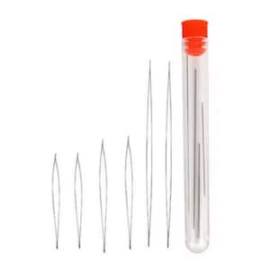 Puede incluir: Colección de enhebradores de agujas y agujas de color plateado. Las agujas están en un tubo de plástico transparente con una tapa naranja. Varios enhebradores están colocados a la izquierda del tubo.