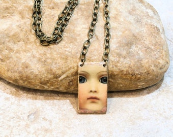 old doll necklace, medallion plaque, unique Poppy In The Sky creation, bronze brass, doll portrait, minimalist