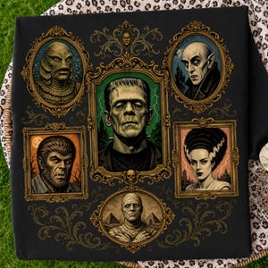 Puede incluir: Un artículo de tela negra con un estampado gráfico de seis monstruos clásicos de películas de terror en marcos dorados ornamentados. El retrato central representa al monstruo de Frankenstein, rodeado por la criatura del lago negro, Drácula, el hombre lobo, la novia de Frankenstein y la momia.