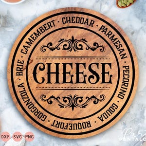 May include: A round wooden cheese board with a black border and the words "CHEESE", "Camembert", "Cheddar", "Parmesan", "Pecorino", "Gouda", "Roquefort", "Gorgonzola", and "Brie" printed around the edge.