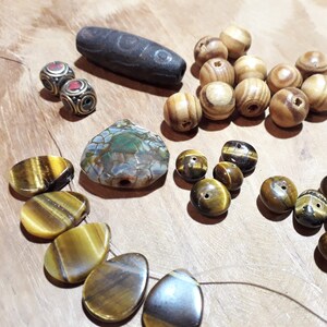 Veel Dzi-kralen en agaat, turkoois, tijgeroog, hout en messing, voor het maken van etnische sieraden.
