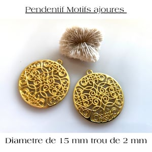 Puede incluir: Dos colgantes de metal dorado con un diseño delicado, circular y calado. Cada colgante mide 15 mm de diámetro con un agujero de 2 mm.