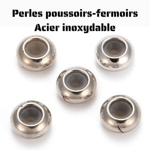 Può includere: Cinque perline in metallo color argento con un foro centrale trasparente. Le perline sono progettate per essere utilizzate come chiusure a pressione per la creazione di gioielli.
