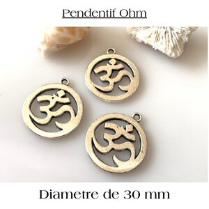 Puede incluir: Tres colgantes plateados con un símbolo Om recortado. Cada colgante tiene un diámetro de 30 mm.