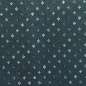 Könnte beinhalten: Dunkelblaugrüner Stoff mit einem sich wiederholenden Muster aus kleinen, weißen, stilisierten floralen oder geometrischen Formen. Das Muster ist gleichmäßig verteilt und erzeugt eine strukturierte Optik. Der Stoff hat einen dezenten Glanz.