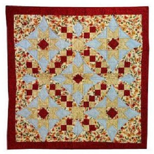 Puede incluir: Una colcha de retazos roja, blanca y azul con un patrón floral. La colcha está hecha de cuadrados y estrellas.