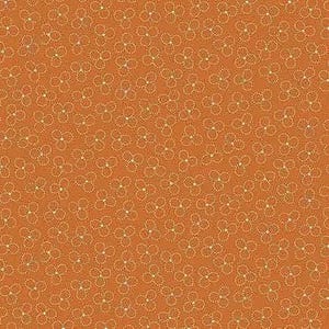May include: Close-up of a fabric with a repeating floral pattern. The background is a warm orange-brown color, and the flowers are a light cream color. The flowers are made up of three circles of small dots.