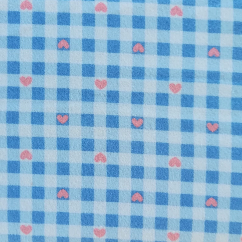 May include: A blue and white gingham fabric with a repeating pattern of pink hearts.