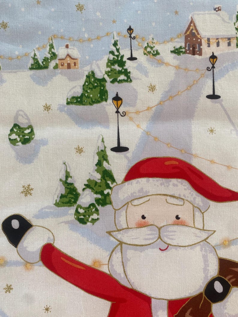 May include: A festive fabric featuring a winter scene with Santa Claus. The design includes snow-covered hills, evergreen trees, houses, and street lamps. Santa is wearing a red suit and hat, with a white beard and a friendly expression.