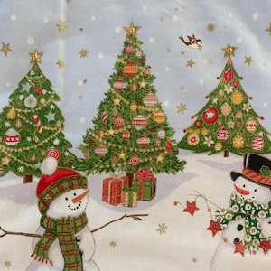 May include: A light blue Christmas-themed fabric featuring decorated green Christmas trees, snowmen, and gift boxes. The trees are adorned with ornaments and topped with gold stars. Snowmen wear hats and scarves. Gold stars and snowflakes are scattered across the background.