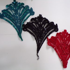 May include: Three sequined fabric appliques in teal, black, and red. Each applique is shaped like a fan with a floral design.