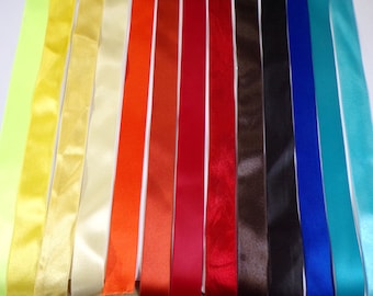 May include: Assortment of 14 satin ribbon spools in various colors, including yellow, orange, red, brown, blue, and turquoise.