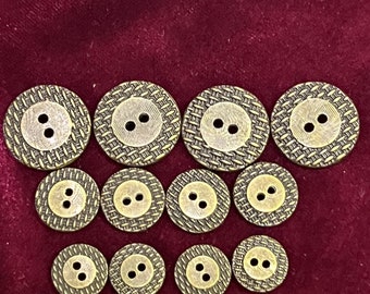 May include: A set of 12 antique gold-toned buttons with a woven pattern and two holes each. The buttons are arranged in a semi-circle on a burgundy velvet background.