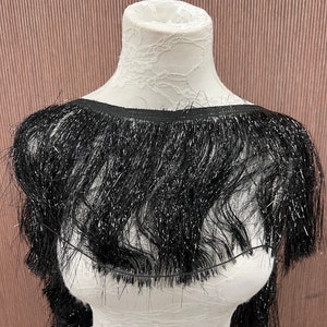 May include: Black fringe trim with a sparkly finish. The fringe is about 2 inches long.