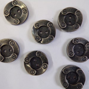 May include: Eight antique gold-toned buttons with a textured black centre and four raised screw heads around the edge.