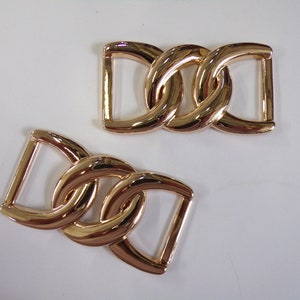 May include: Two gold-toned metal chain link buckles. Each buckle is made of two interlocking rings.