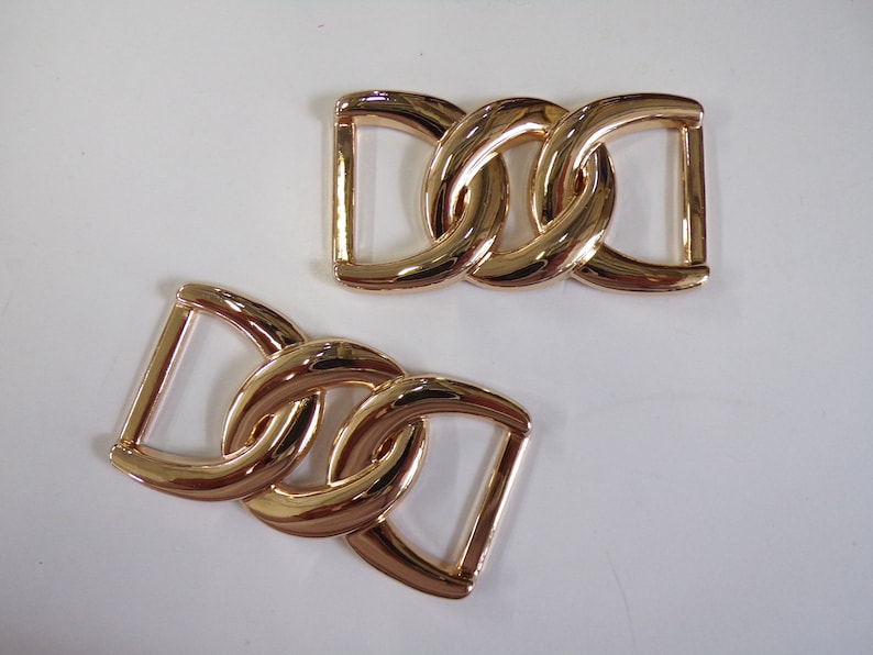 May include: Two gold-toned metal chain link buckles. Each buckle is made of two interlocking rings.