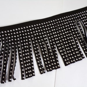 May include: Black fringe trim with silver rhinestones. The fringe is approximately 2.5 cm long.