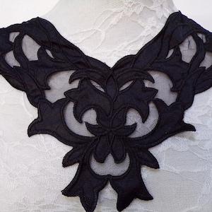 May include: Black lace trim with a floral design. The trim is made of a sheer fabric with a delicate floral pattern. It is perfect for adding a touch of elegance to any garment.