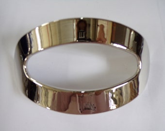 May include: A shiny silver oval-shaped ring with a smooth, polished finish.