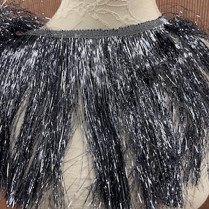 May include: Black fringe trim with silver glitter. The fringe is about 2 inches long.