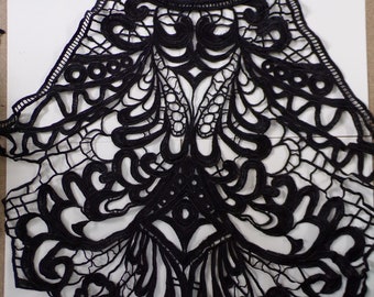 May include: Black lace trim with a delicate floral pattern. The trim is designed for use on clothing or other craft projects.