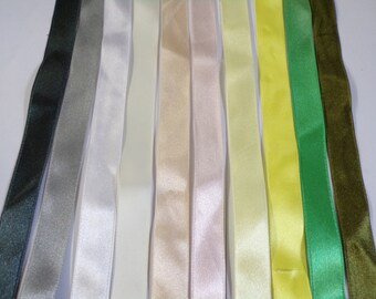 May include: Assortment of ten satin ribbon spools in various colors, including black, gray, white, cream, beige, light pink, light yellow, yellow, green, and brown.