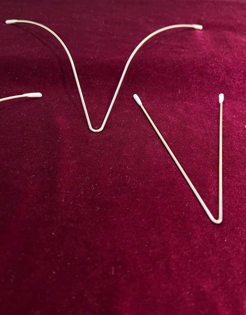 May include: Three white cotton swabs with a thin metal wire bent into a V shape.