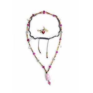Peut inclure: Un collier multi-rangs avec un pendentif en forme de tête de Bouddha rose sculptée, des perles magenta vives et de petites perles de rocaille multicolores. Il comporte des breloques circulaires argentées avec des symboles Om et un cordon noir.