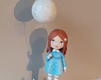 Little girl sculpture in blue and her moon balloon