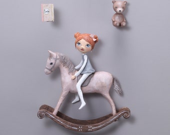 Mobile petite fille et son cheval à bascule