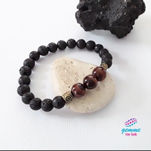 May include: A black lava stone beaded bracelet with three tiger's eye beads and a gold-toned spacer bead.