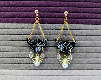 Brincos de teia de aranha com pingentes de aranha e detalhes em pedra falsa.