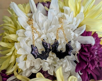 Brincos de morcego com detalhes em glitter roxo