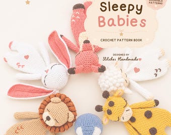 May include: A crochet pattern book titled Sleepy Babies featuring six animal designs including a white rabbit, a pink fox, a white sheep, a tan lion, a blue penguin, and a yellow giraffe arranged in a circle on a light background.